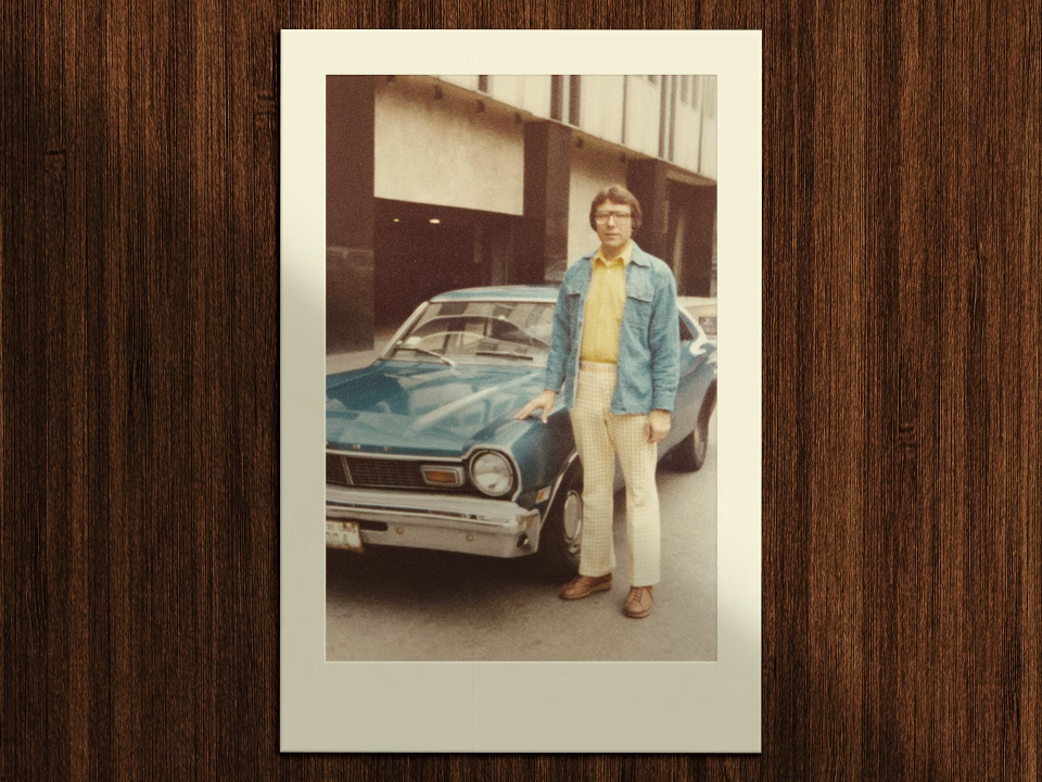DaleCar » Tree9 Films Polaroid-style photo of a man in a denim jacket and yellow shirt standing beside a blue vintage car on a city street, 1970s vibe.
